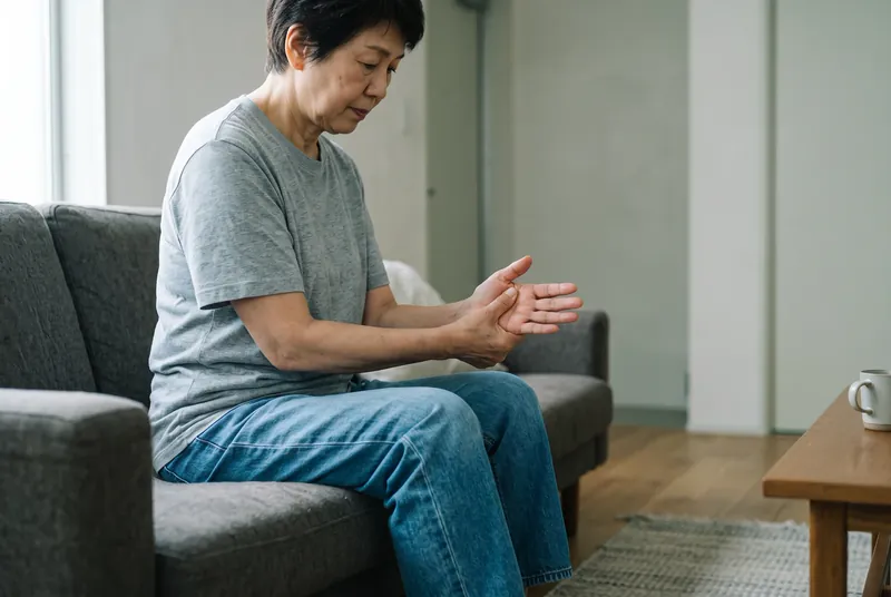 Person holding their wrist and hand in discomfort