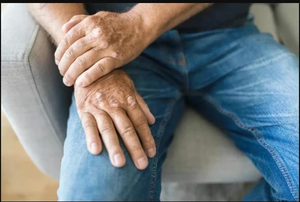 Person with arthritis pain holding their own hand and wrist
