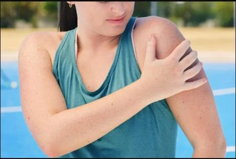 Person holding their shoulder in pain after a sports injury